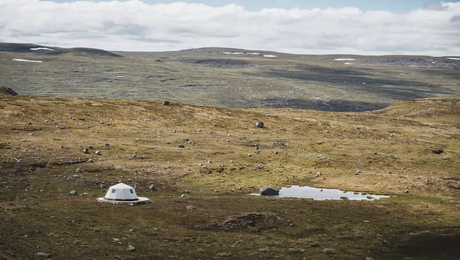 A glamping tent belonging to Dyranut Fjellstova, sitting right by a small mountain lake.