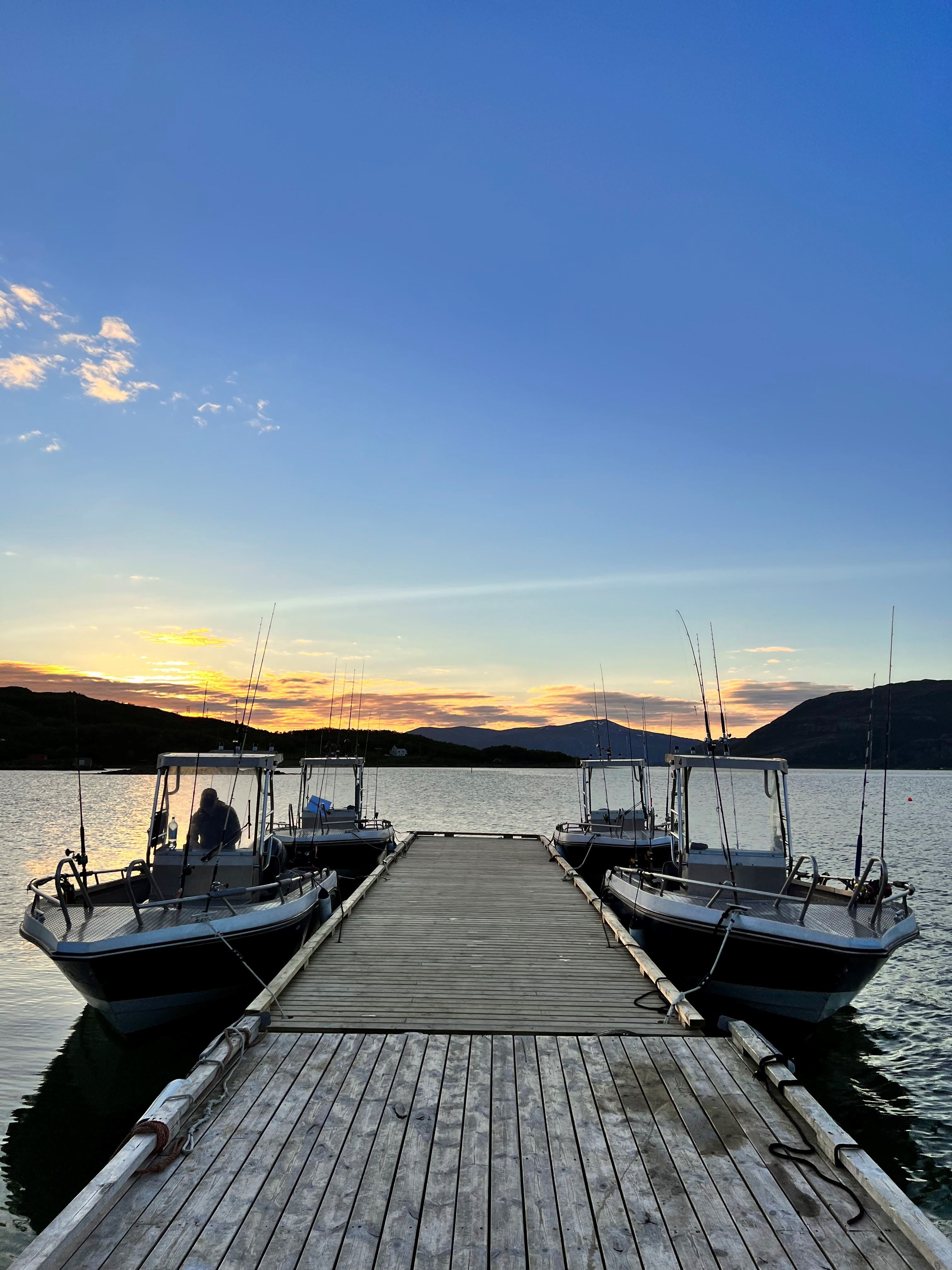The harbour by the cabins where four boats are ready for you to go out on the fjord sightseeing or fishing