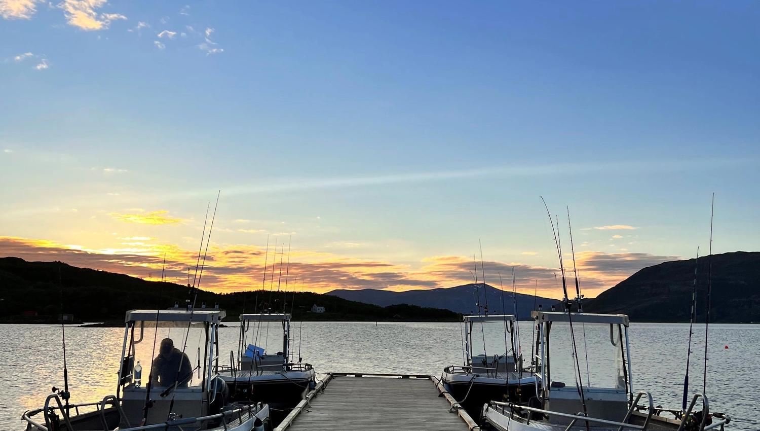 The harbour by the cabins where four boats are ready for you to go out on the fjord sightseeing or fishing