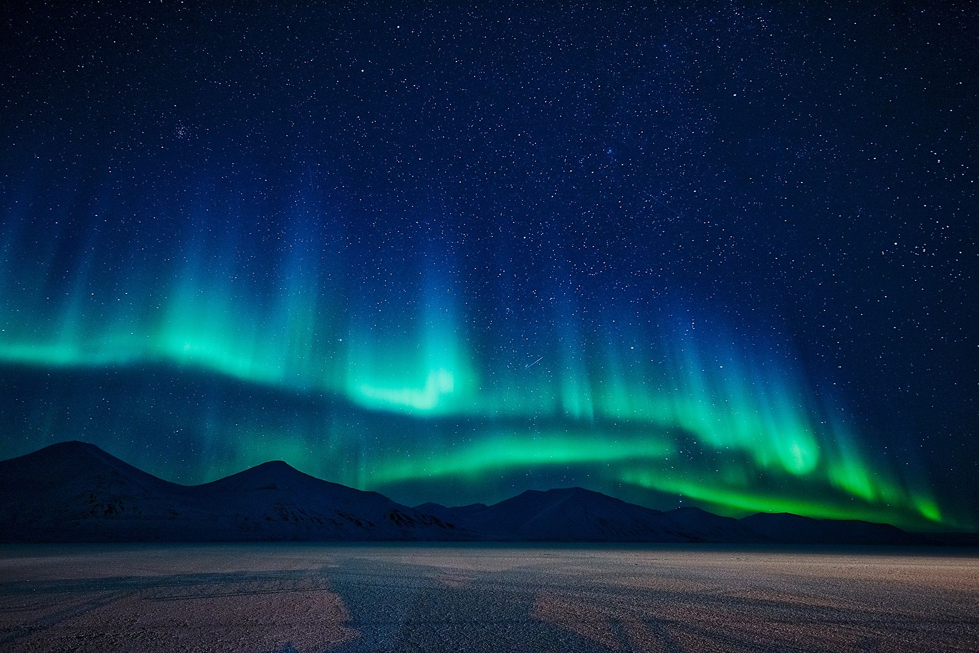 Nordlys som skinner over fjell