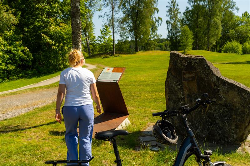 Syklist som kikker på informasjon på historisk grunn