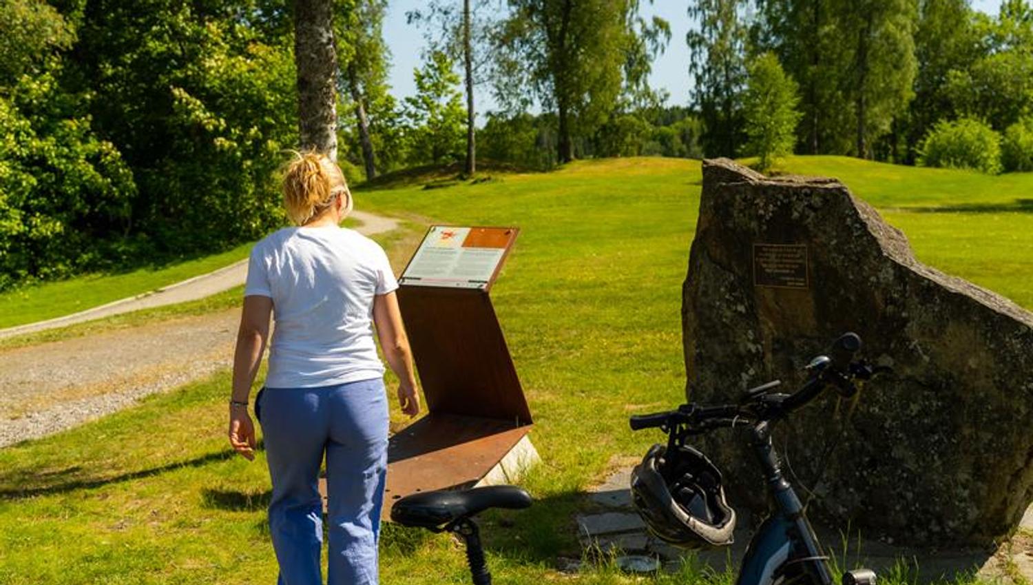 Syklist som kikker på informasjon på historisk grunn