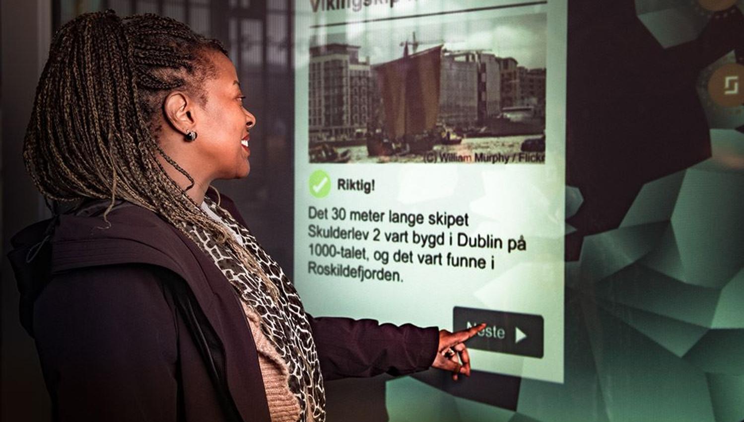 A visitor using an information screen to learn more about the Viking Age.
