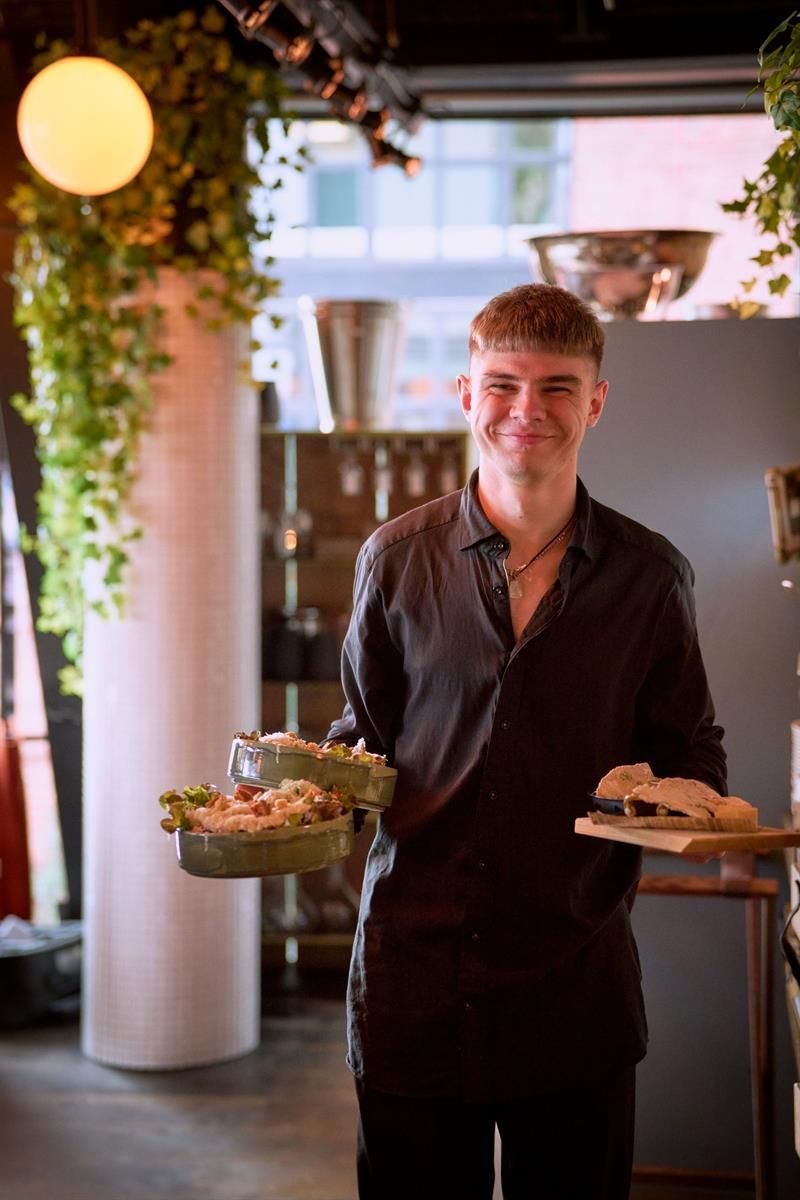 A server carries multiple plates with finished dishes. Service is delivered directly from kitchen to table.