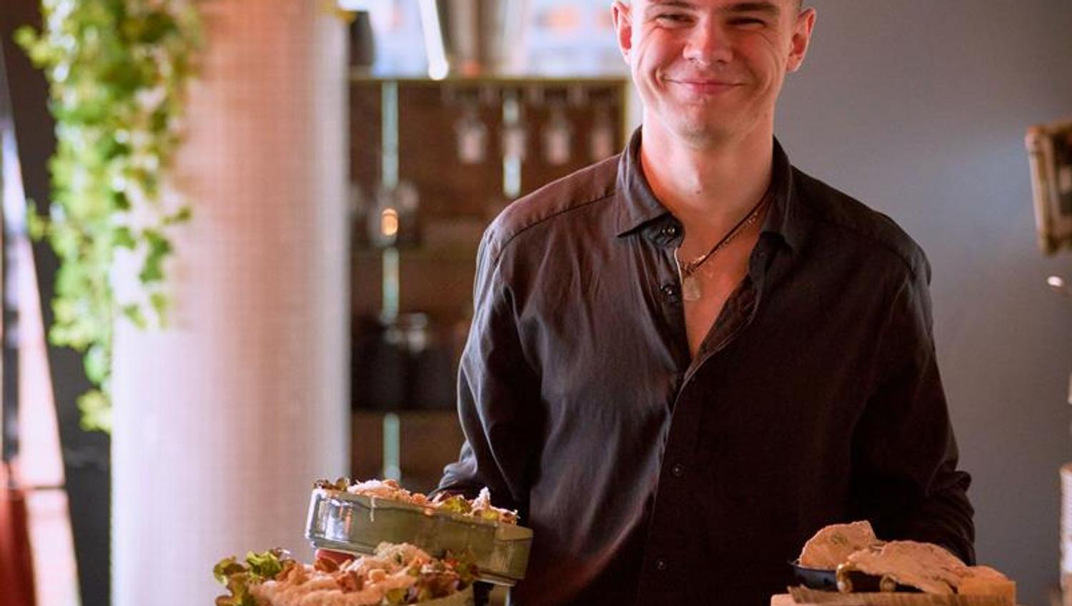 A server carries multiple plates with finished dishes. Service is delivered directly from kitchen to table.