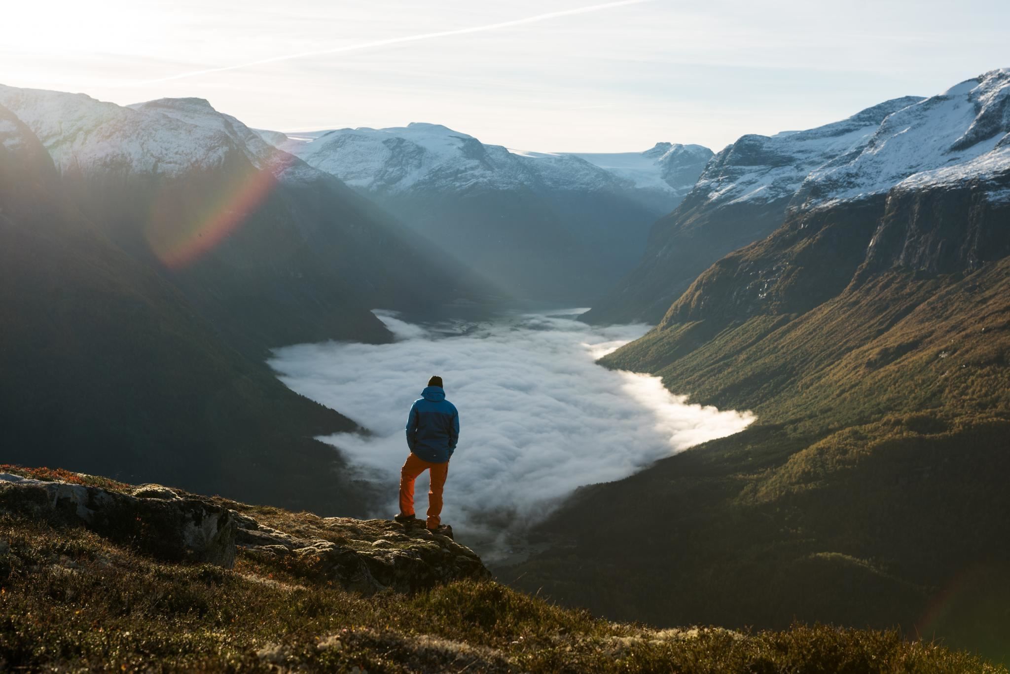 Hiker looking out over the fjord and mountain landscape from a viewpoint at Hoven.