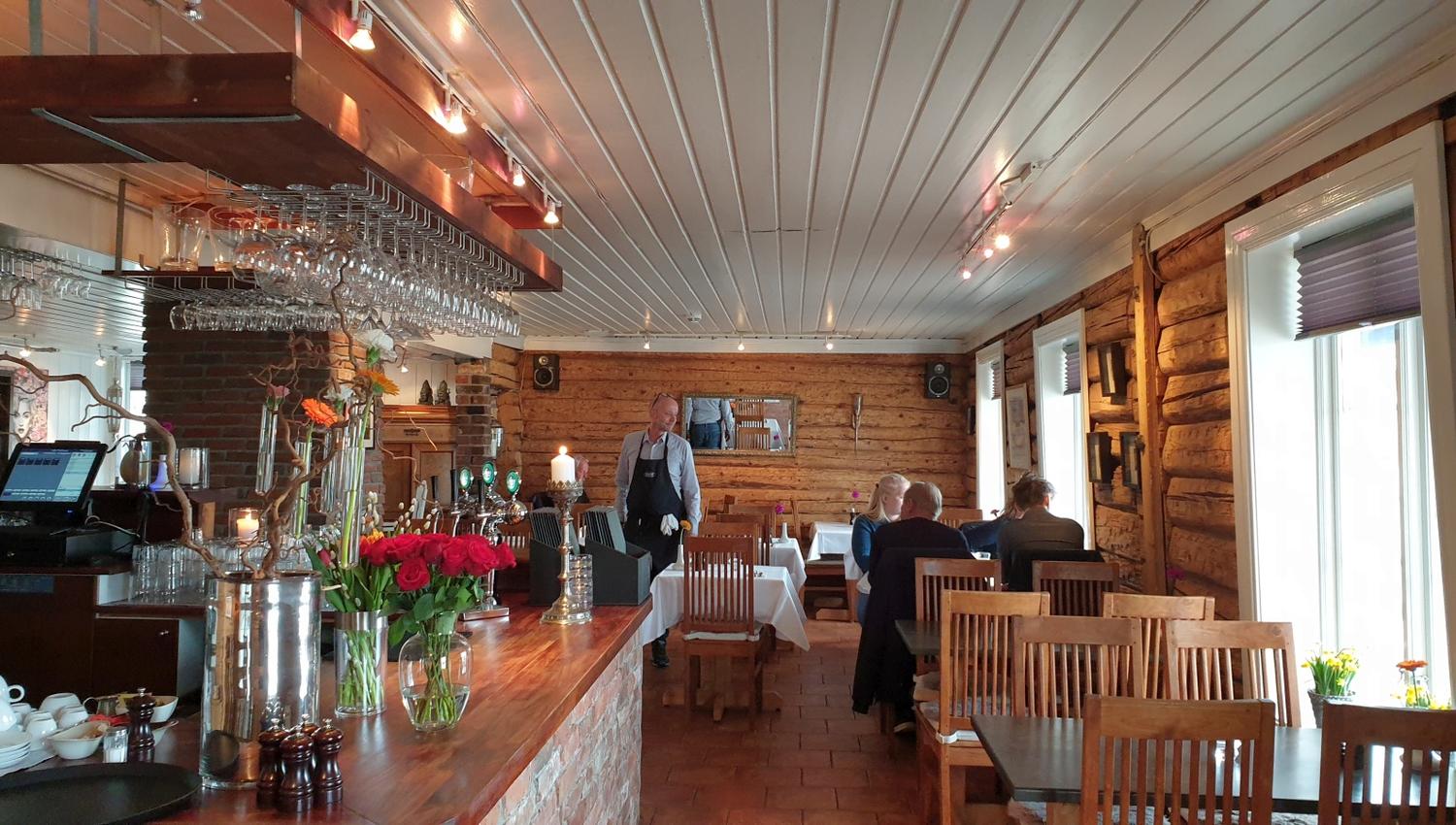 Restauranten inne med bord og trevegg