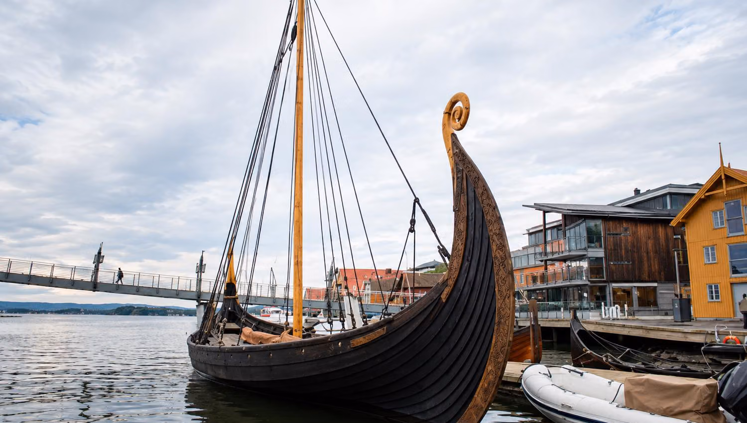 Rekonstruert vikingskip med utskåret stavn, mast og rigg fortøyd ved Vikingodden i Tønsberg.