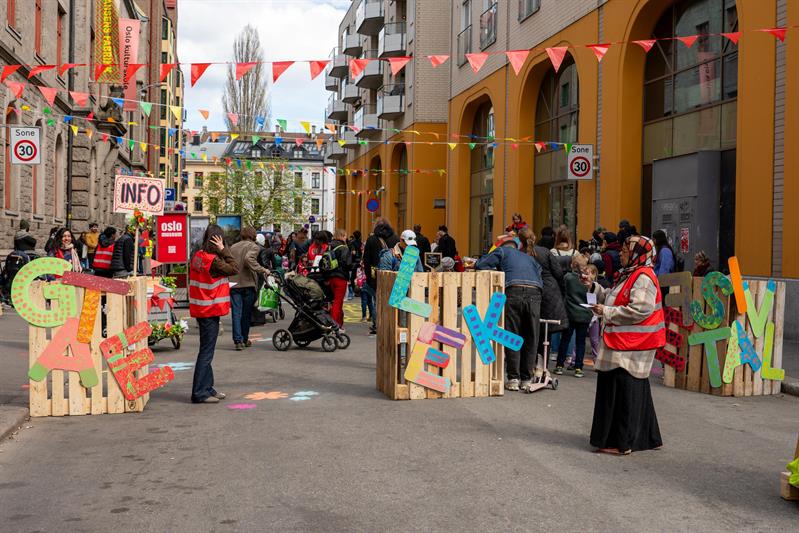 Street event outside the museum featuring colourful bunting, information stands and people gathered along the street.