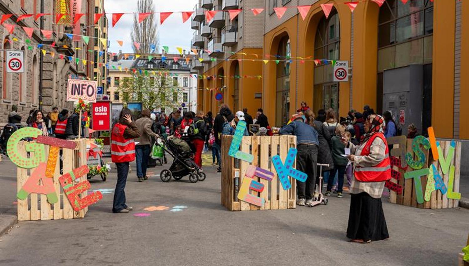 Street event outside the museum featuring colourful bunting, information stands and people gathered along the street.