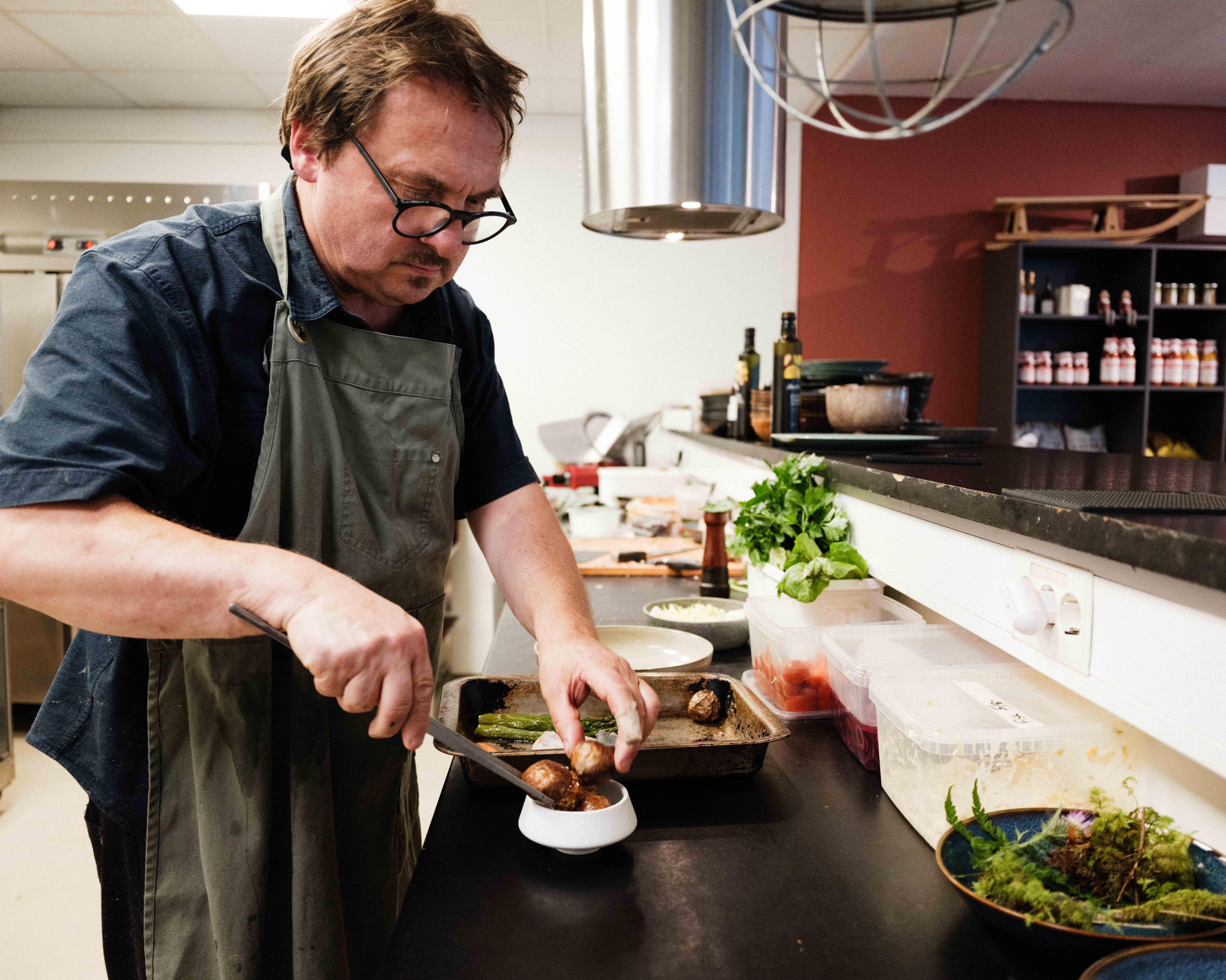 The chef prepares a rustic dish with meatballs and vegetables at Gløyp Spiseri in Hardanger.