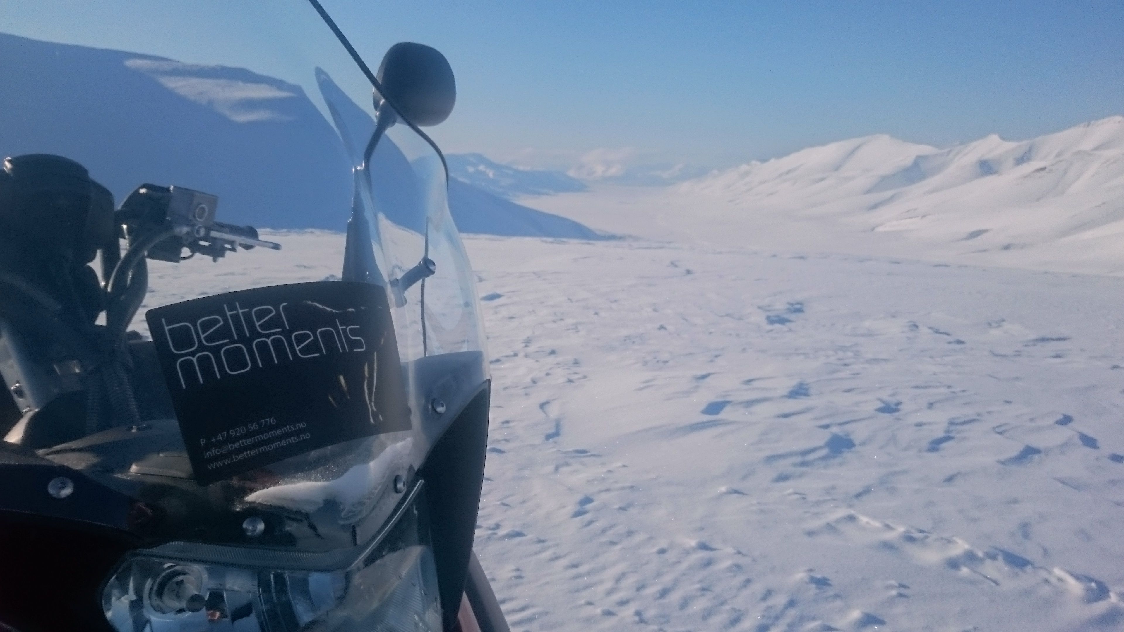 Snowmobile in the front. snowcovered landscape seen in the background 