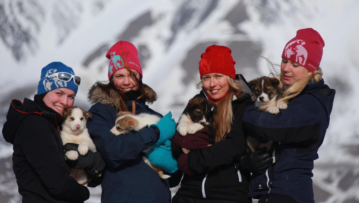People holding puppies in their arms