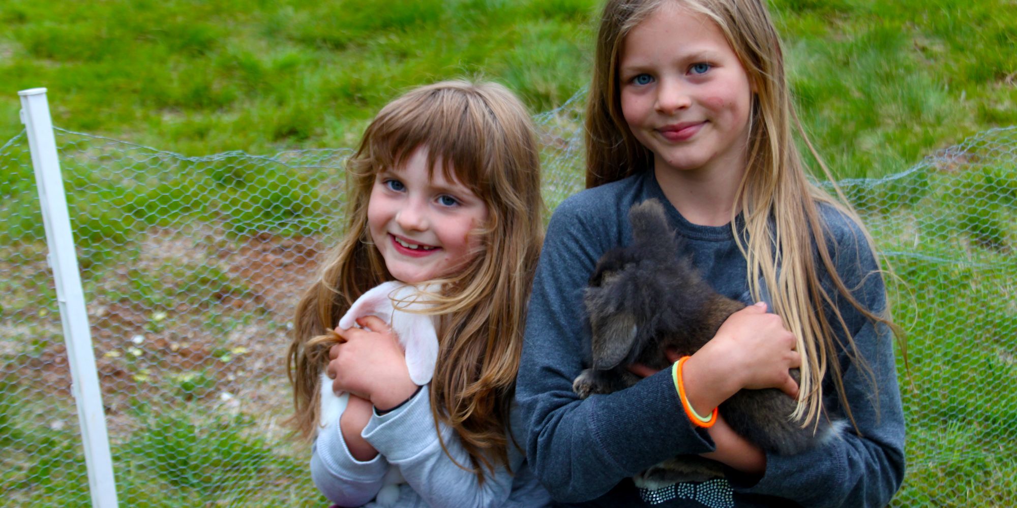 2 content girls petting the rabbits at Holsingsetern summer mountain farm