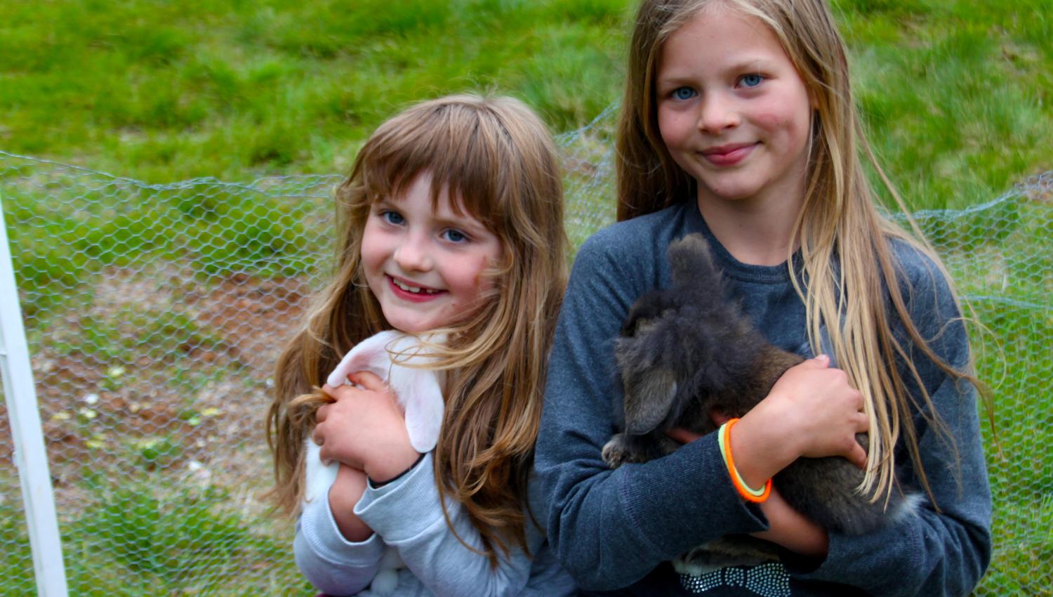 2 content girls petting the rabbits at Holsingsetern summer mountain farm