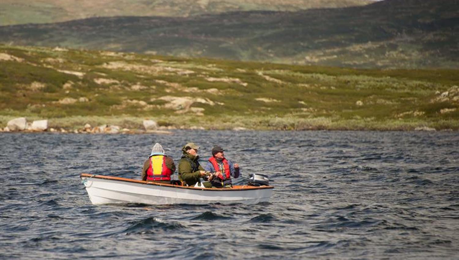 Drei Personen angeln von einem kleinen Boot aus auf dem See Halnefjorden.
