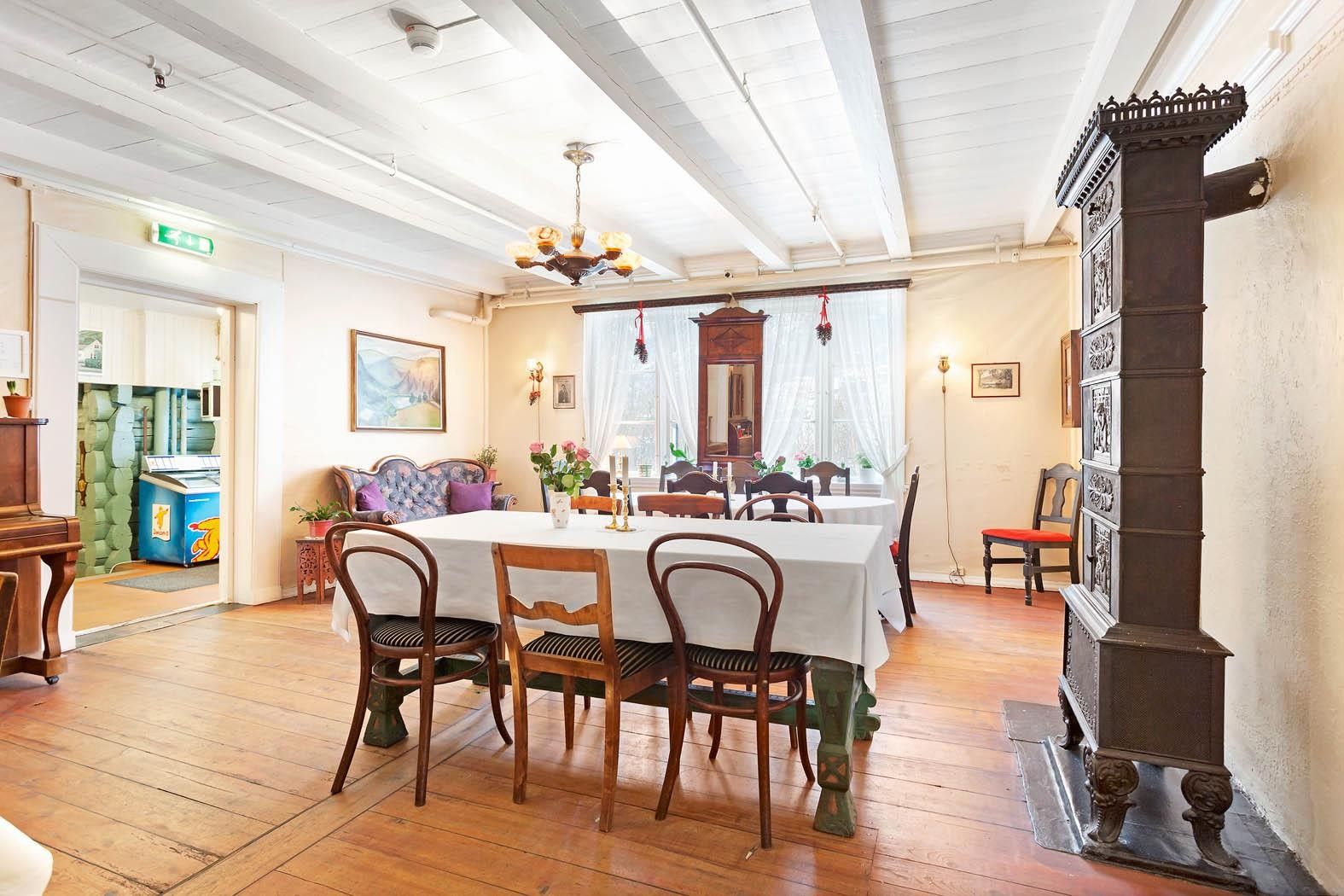 Elegant dining room with antique furniture and piano at Jaunsen Guesthouse in Hardanger.
