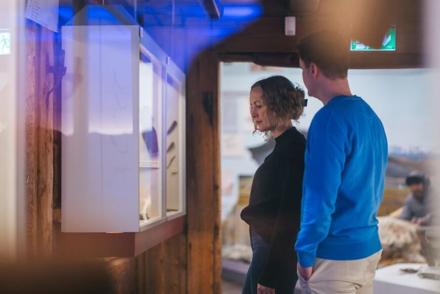Two persons studying an exhibition at The Polar Museum in Tromso