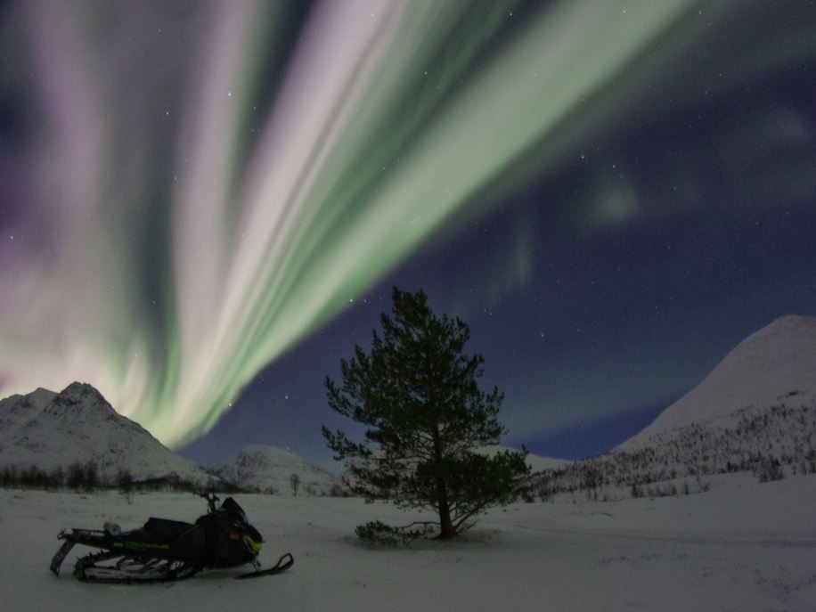 A snowmobile under the northern lights