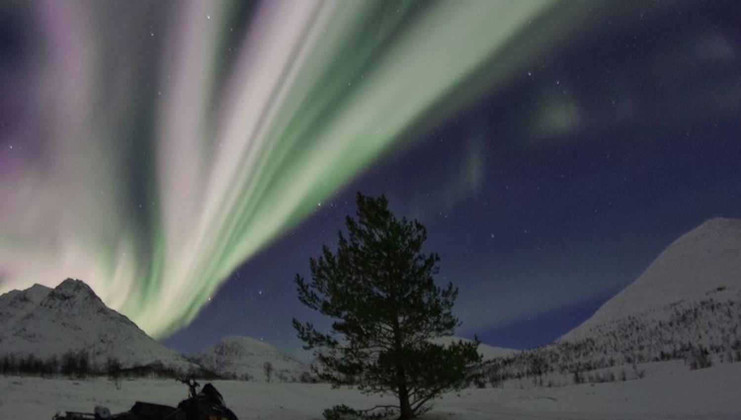 A snowmobile under the northern lights