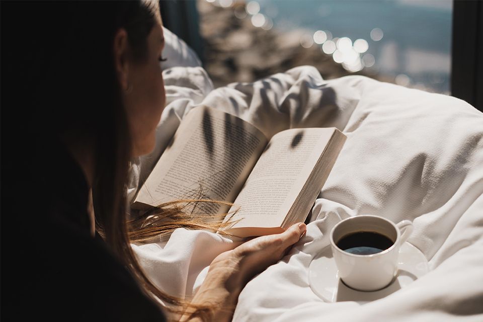 Person reads a book with a cup of coffe