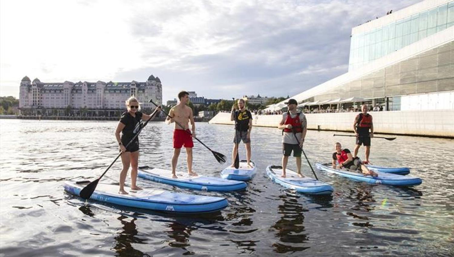 Five paddlers in front of the Opera House.