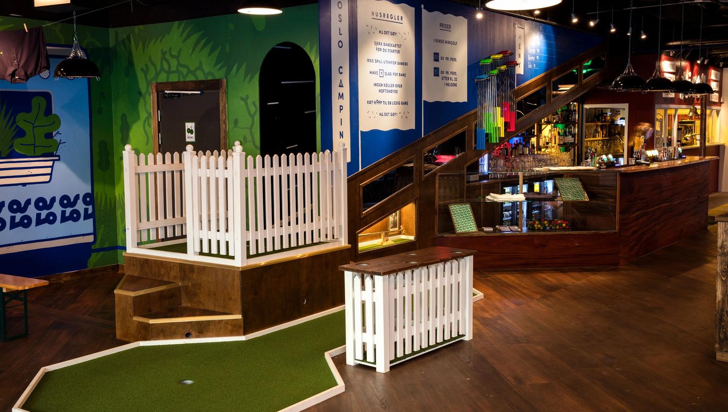 Interior: mini golf course with bar in the background