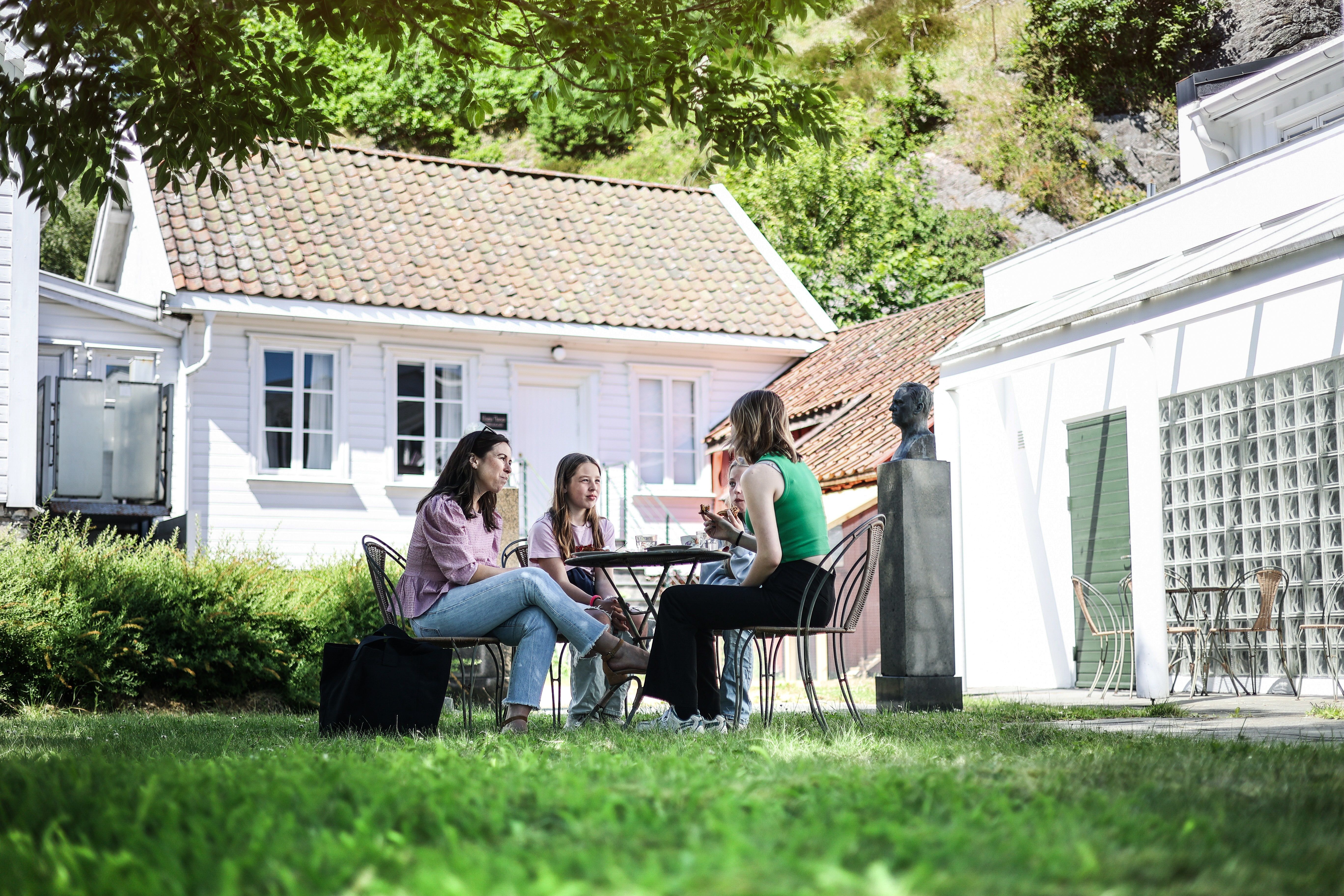 A group is sitting around a picnic table and eating.

