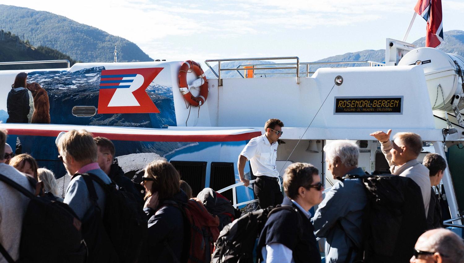 People gathering by Hardangerfjordekspressen, ready for a fjord journey with Rødne Fjord Cruise.