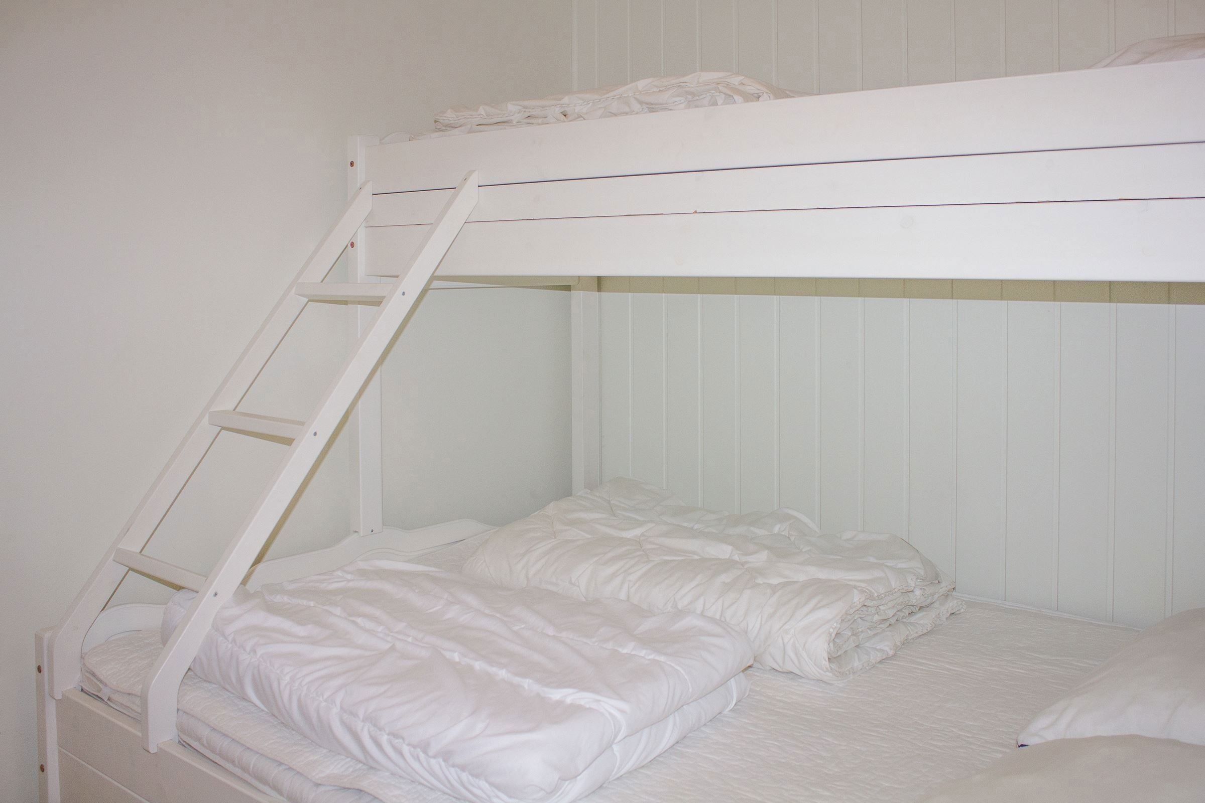 A bunk bed with ladder and blankets.