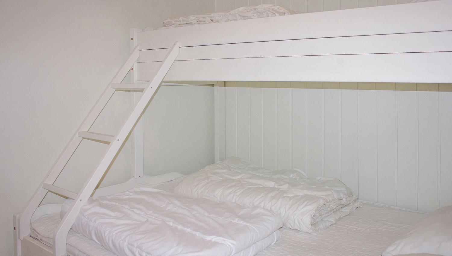 A bunk bed with ladder and blankets.