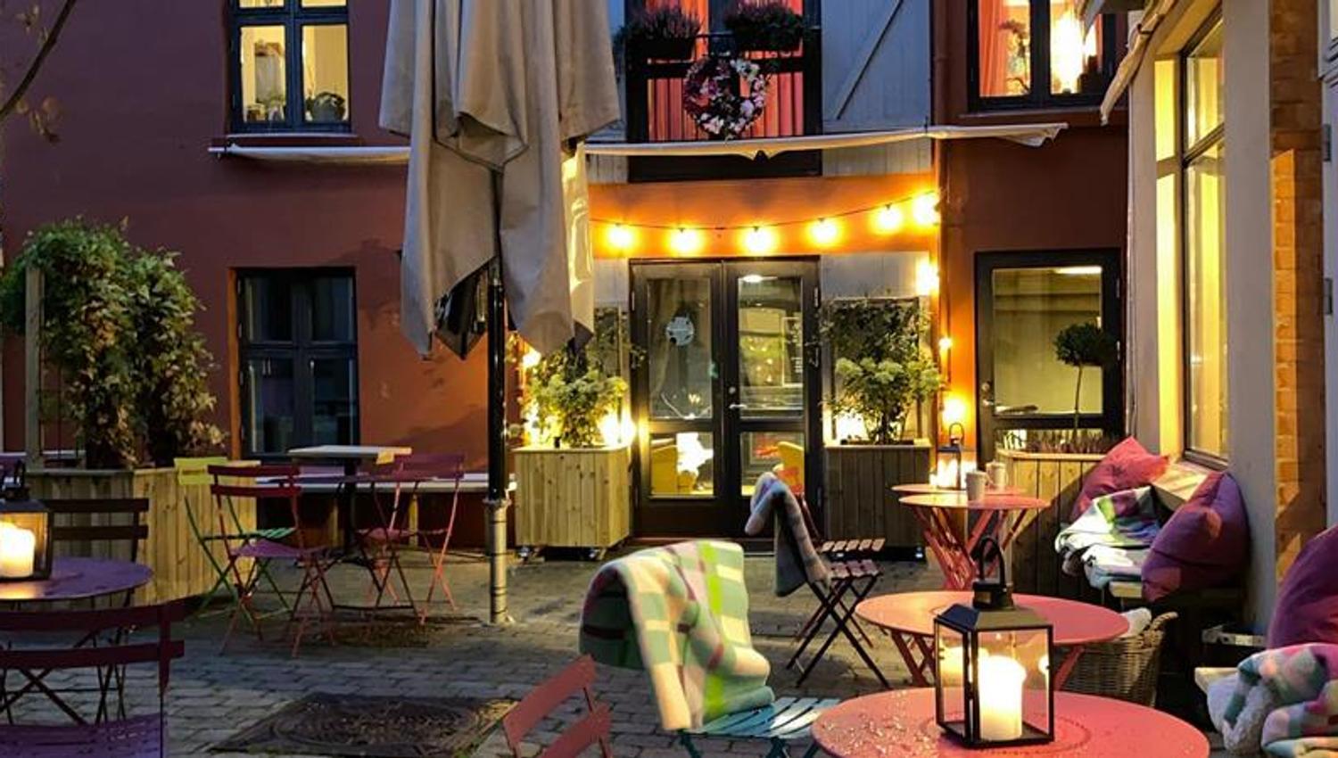 Bakgård med rosa bord og stoler