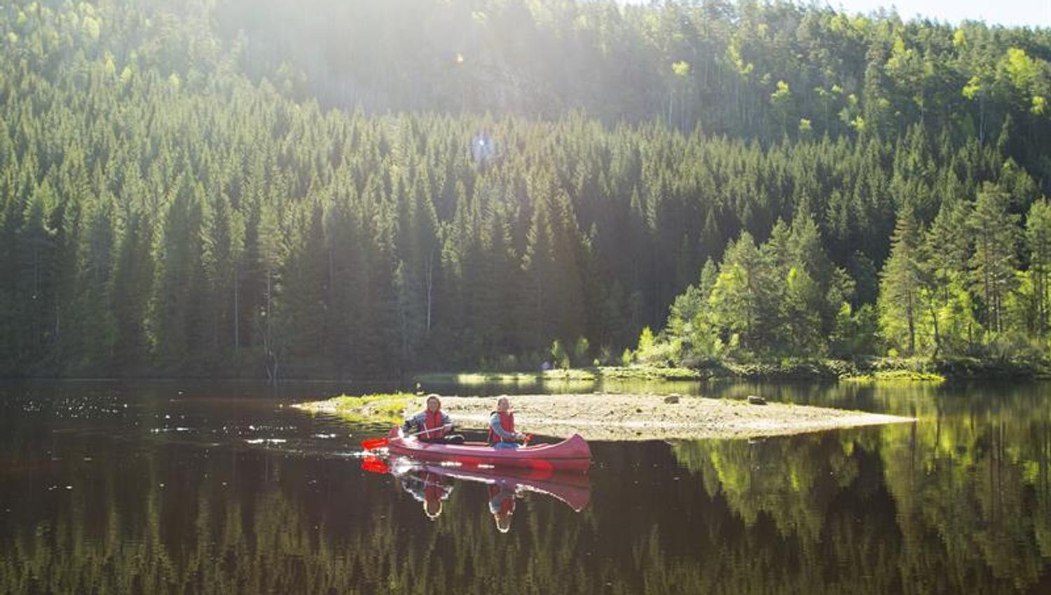 Two people in a red canoe paddling on the water