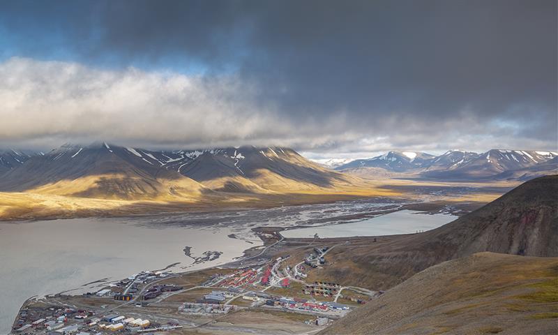 Buildings in Longyearbyen in the foreground with an overcast mountainous landscape in the background