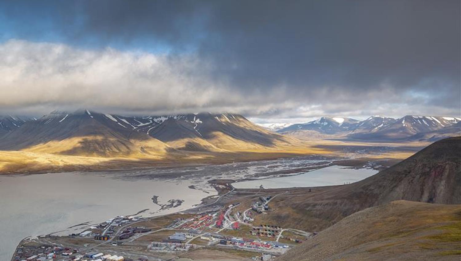 Buildings in Longyearbyen in the foreground with an overcast mountainous landscape in the background