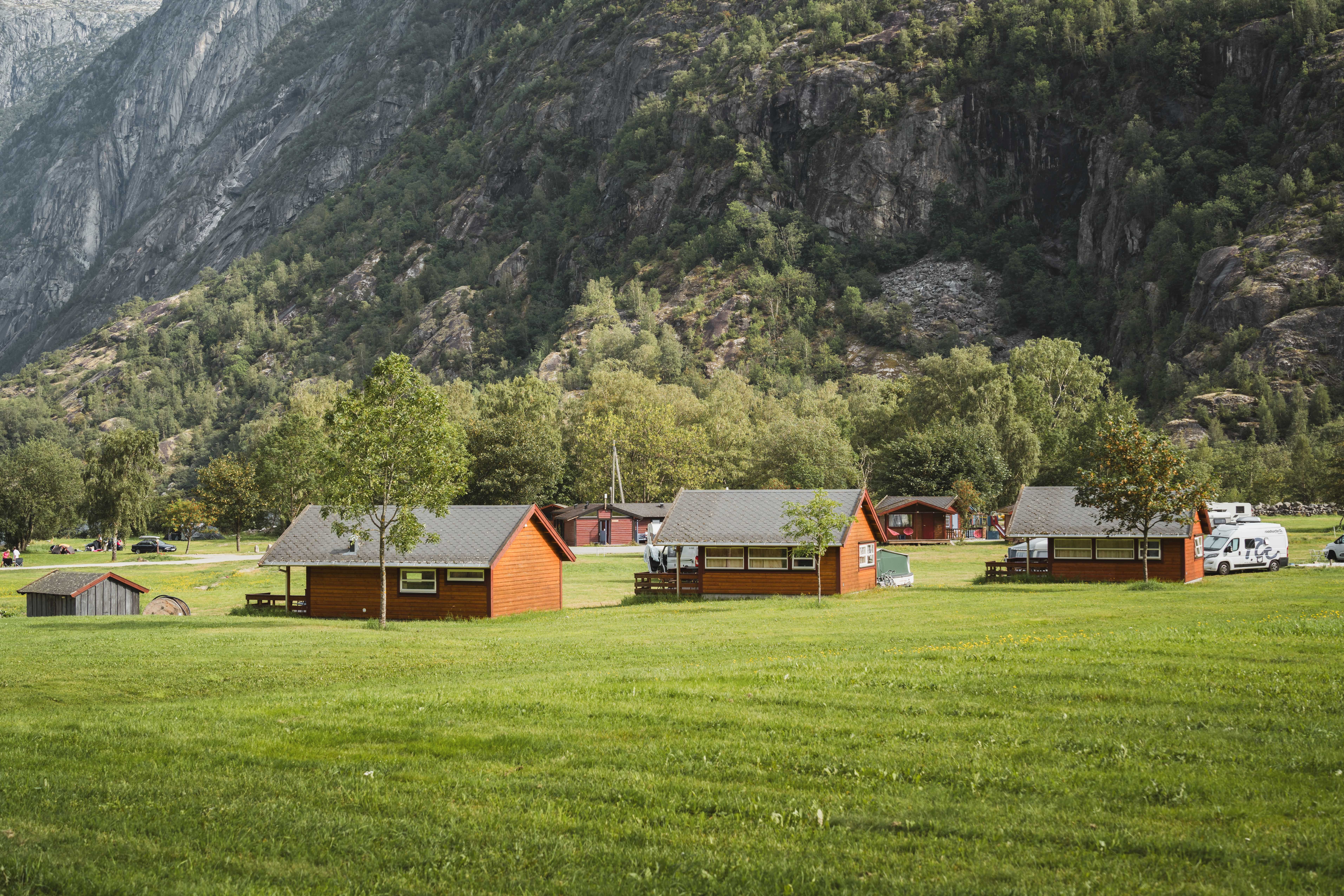 Three cabins lined up on the field at Sæbø camping.