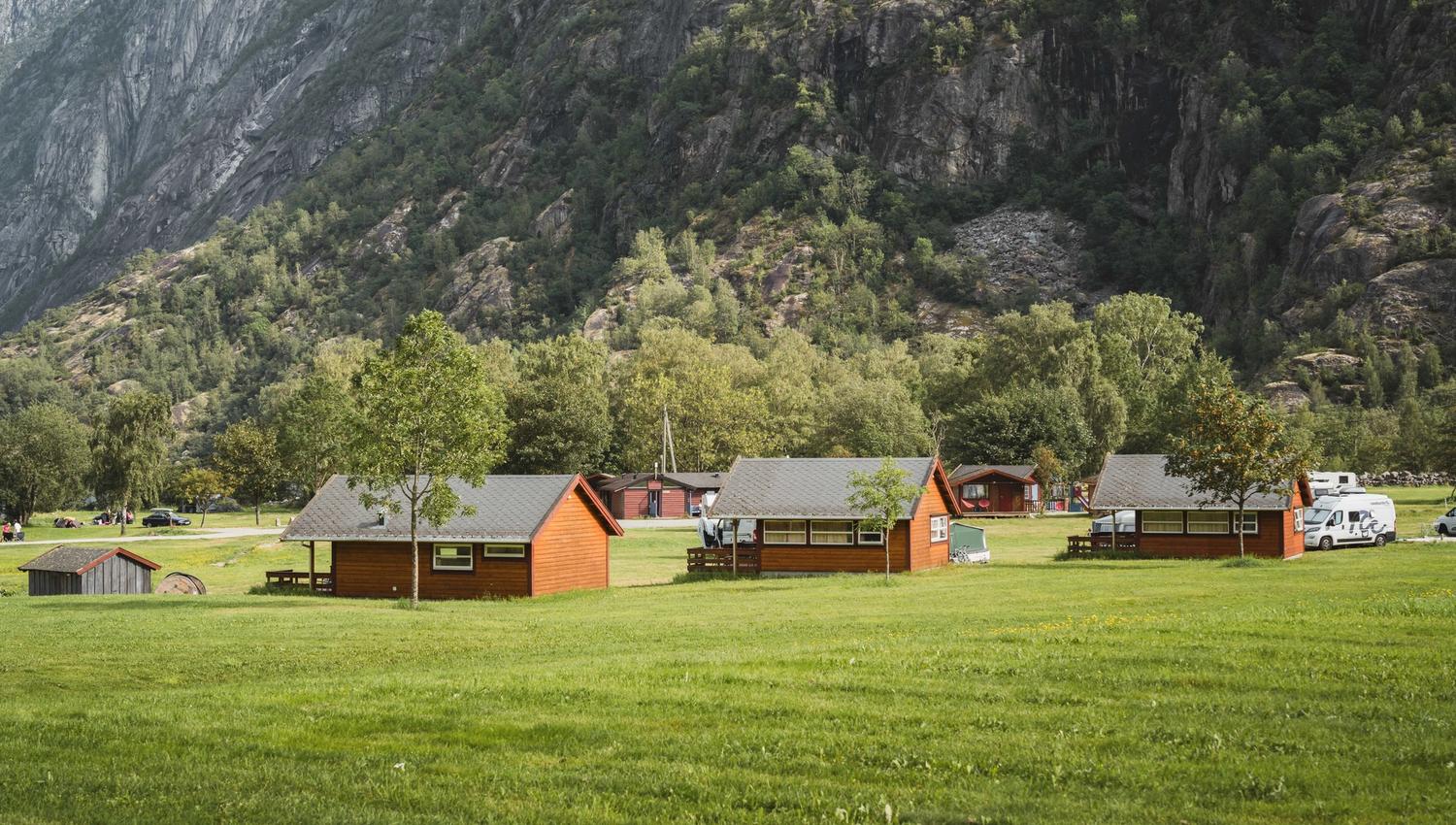 Three cabins lined up on the field at Sæbø camping.