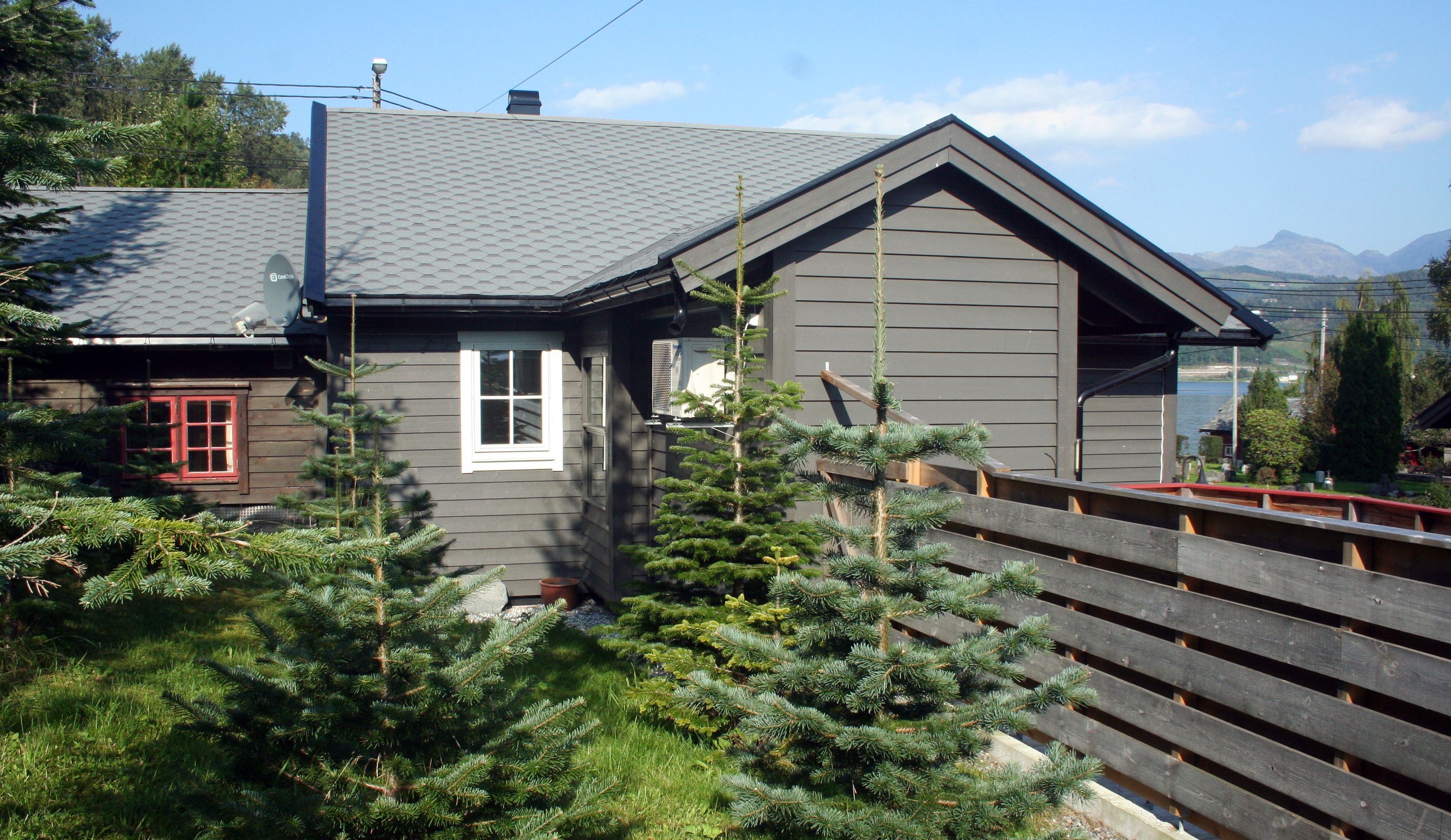 Cozy cabin surrounded by small spruce trees at Vågen Rom og Hytteutleige in Hardanger.
