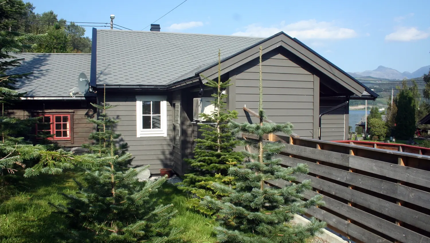 Cozy cabin surrounded by small spruce trees at Vågen Rom og Hytteutleige in Hardanger.