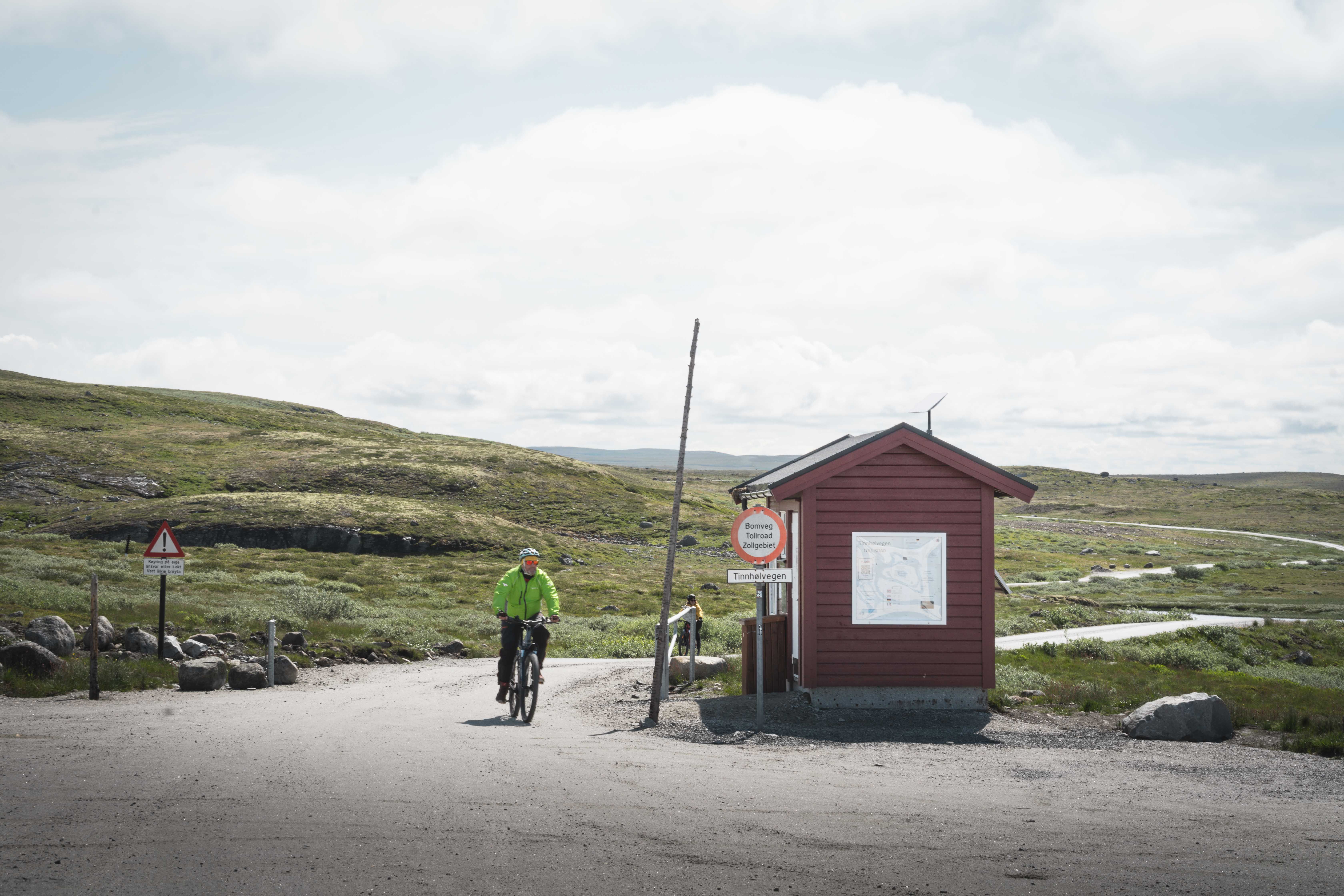 A biker by the toll hut by the entrance to the Tinnhølen mountain road.