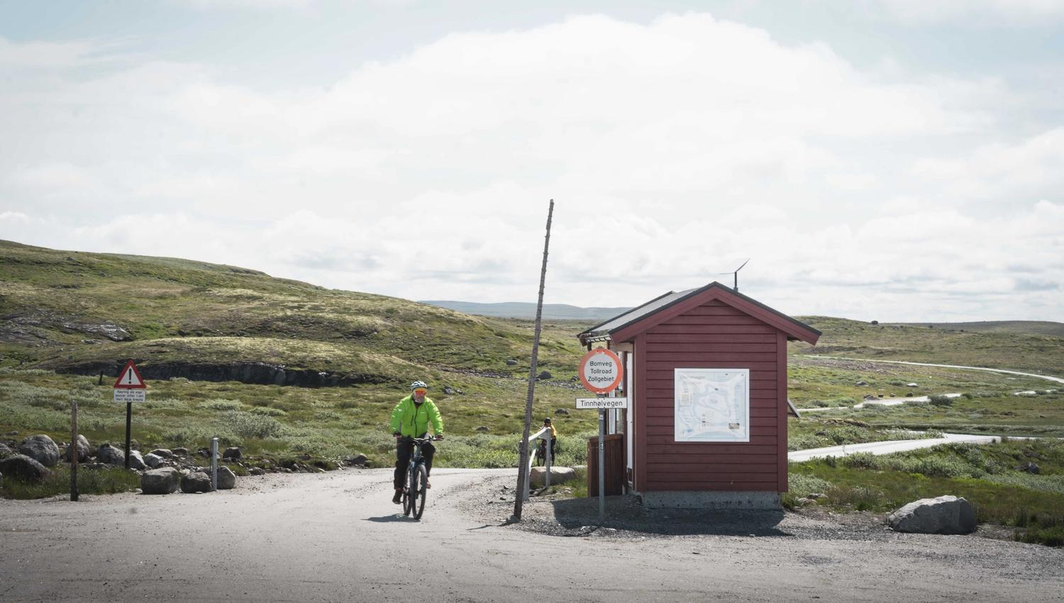 A biker by the toll hut by the entrance to the Tinnhølen mountain road.