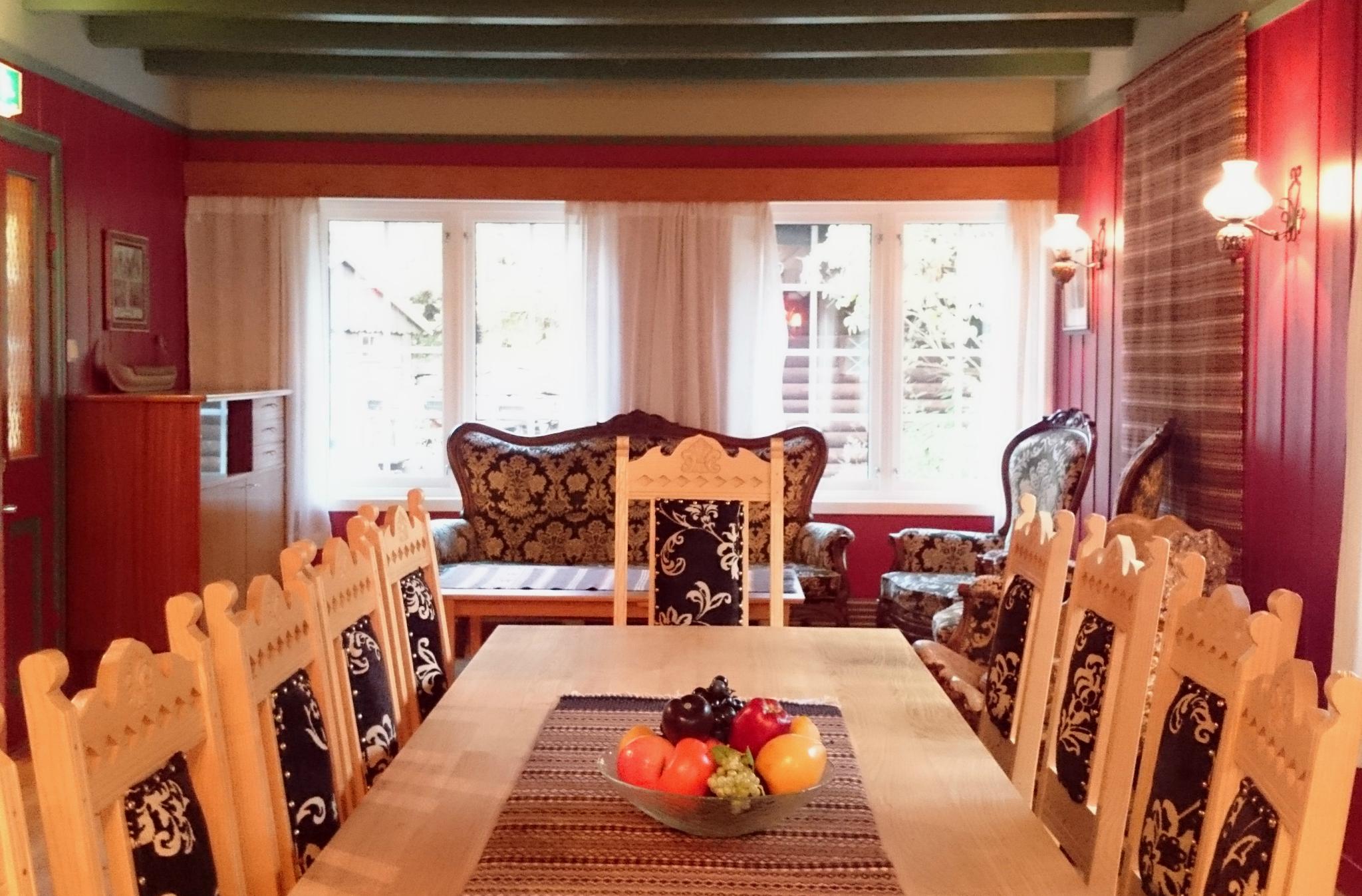 Bright and cozy lounge at Ullensvang Gjesteheim featuring traditional furniture, embroidered details and views toward the garden.
