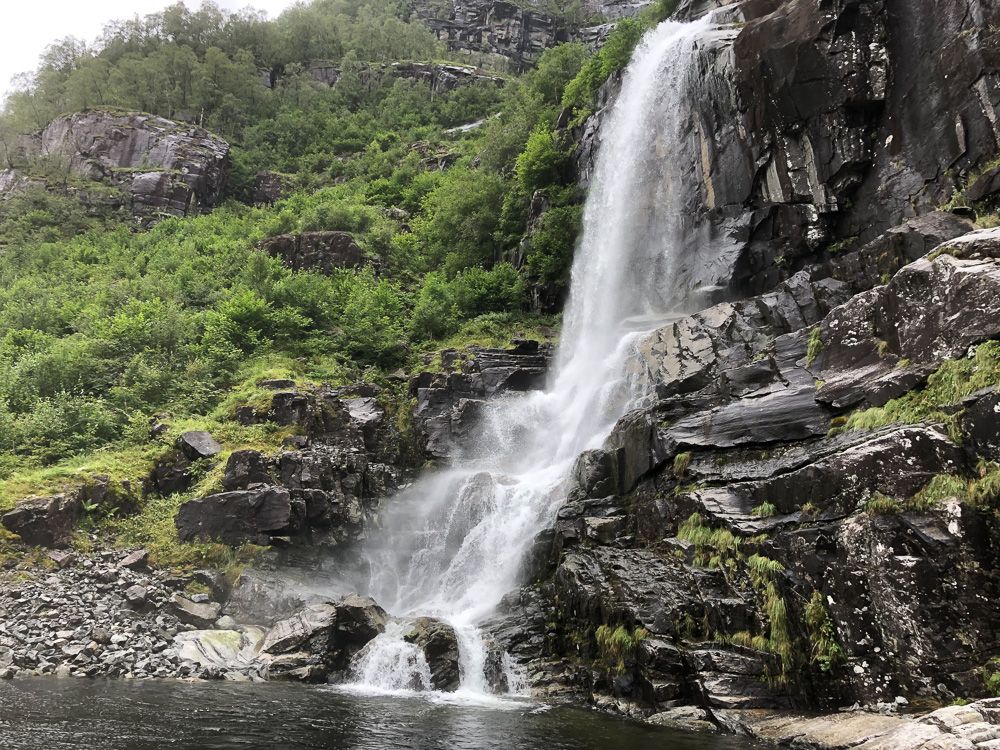 A majestic waterfall surrounded by lush nature in the Hardangerfjord, a highlight of the Norheimsund RIB Seafari.