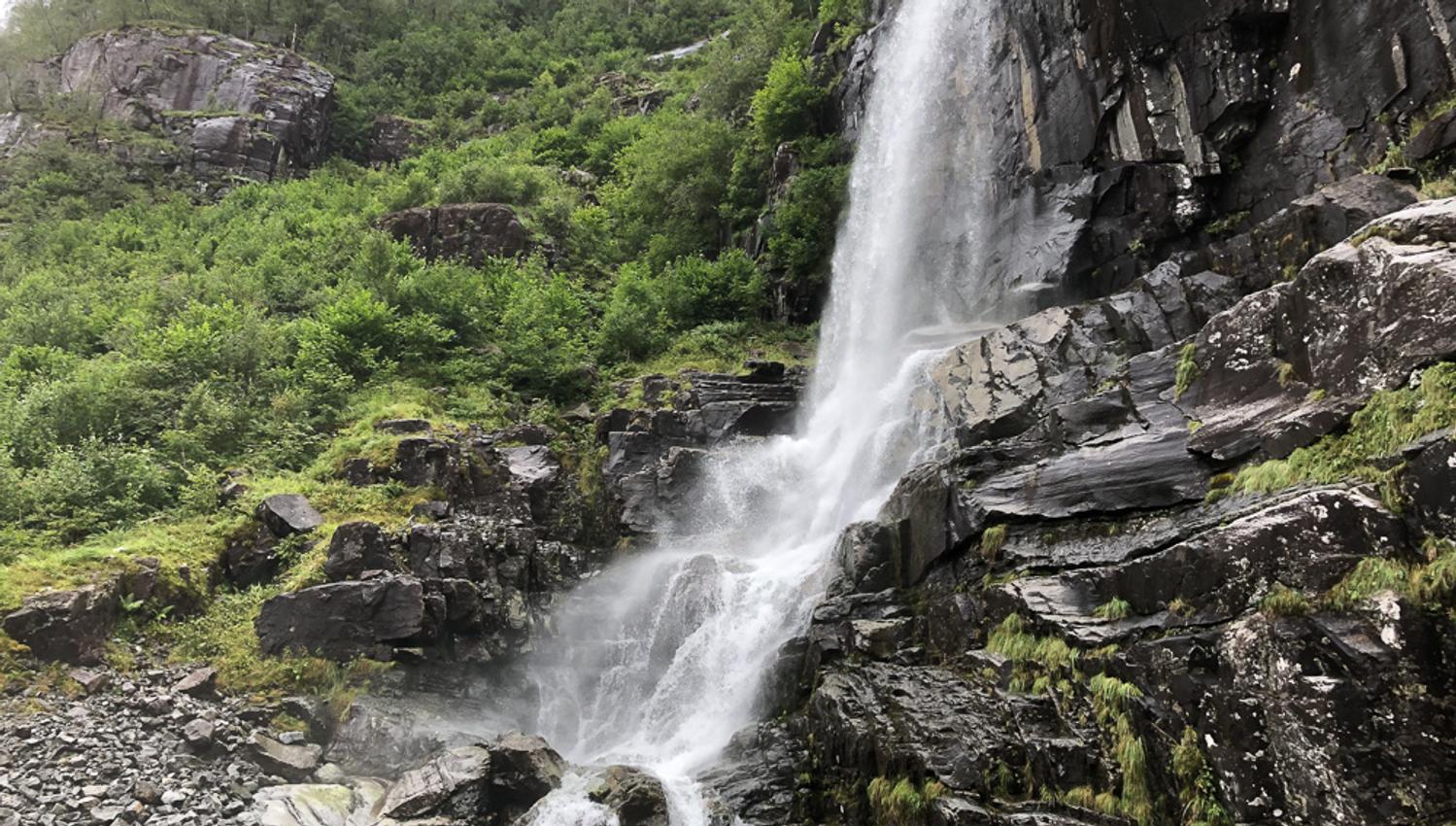 A majestic waterfall surrounded by lush nature in the Hardangerfjord, a highlight of the Norheimsund RIB Seafari.