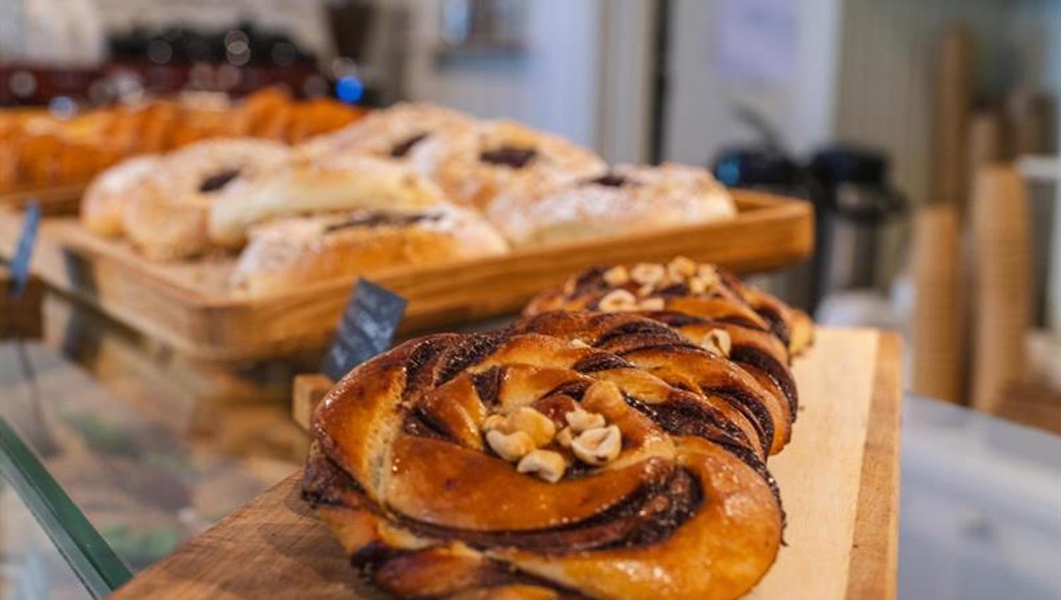 Cinnamon buns in front and other baked goods in the background.
