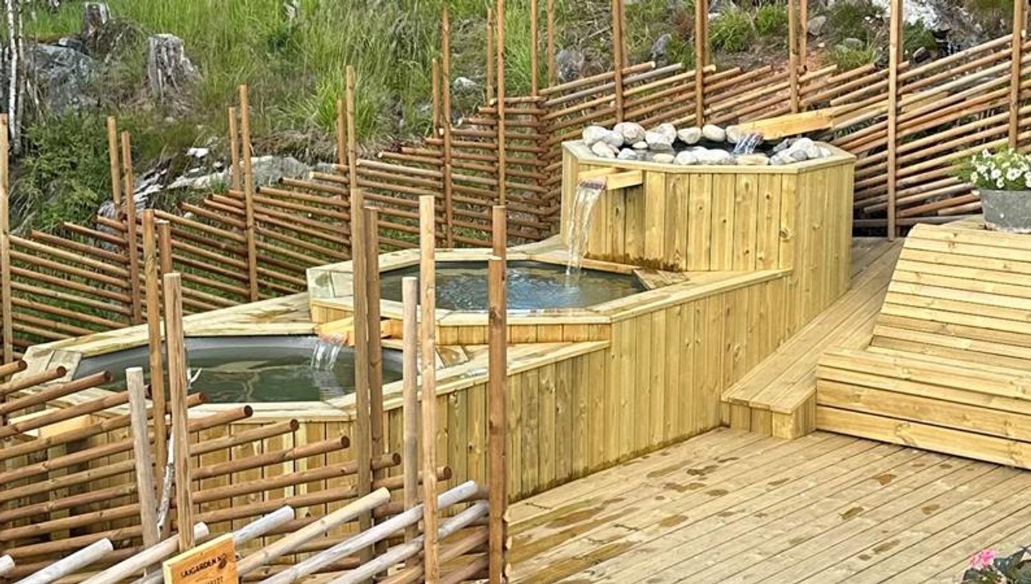 Cold plunge pool in scenic natural surrounding with wooden decking and nature-inspired design, surrounded by forest and rocks