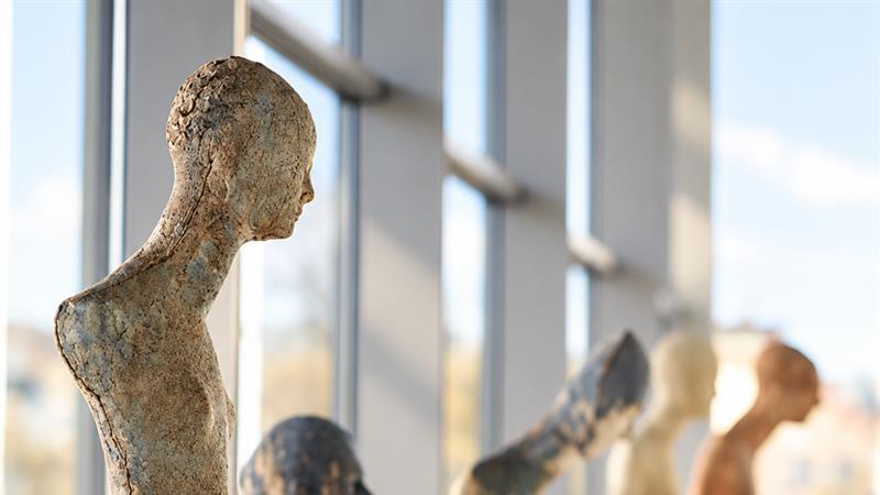 Several figurative sculptures displayed on white pedestals in a bright exhibition space at Larvik Kunstforening's Galleri Bølgen.