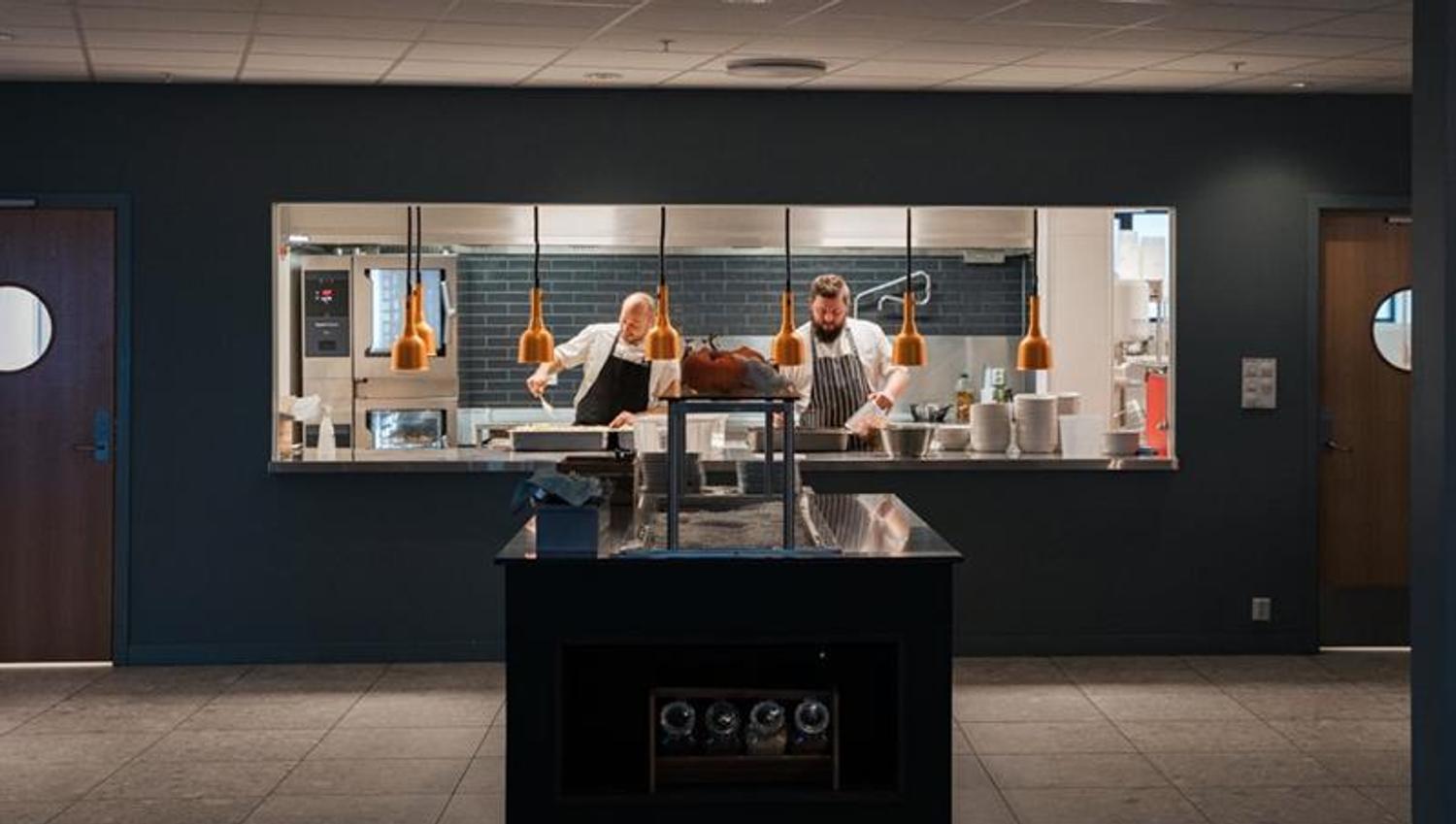 Two chefs are preparing food in the kitchen of an restaurant