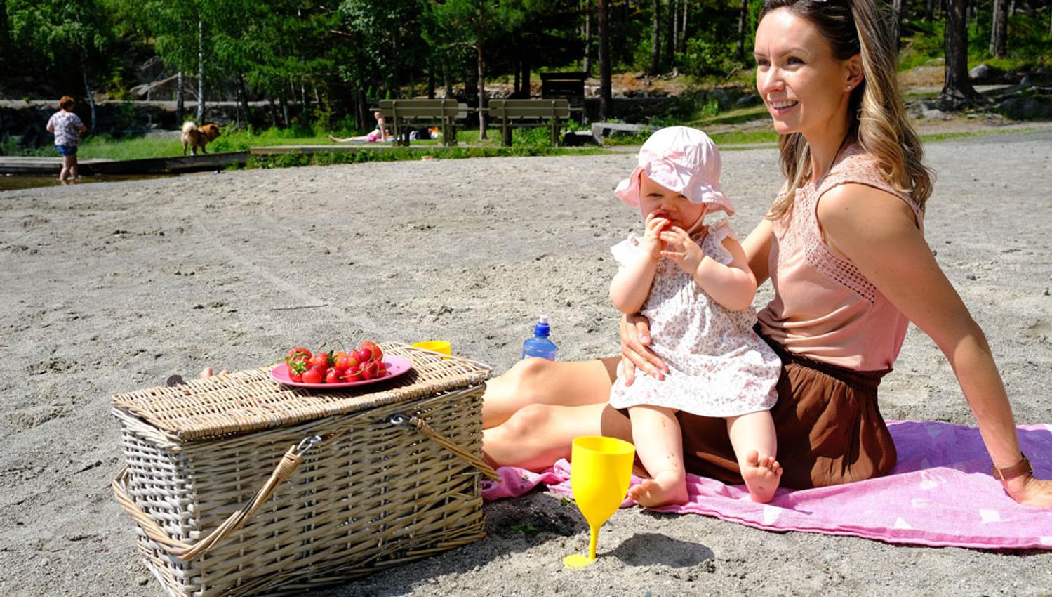 Mor og baby på stranden på Tinnemyra i Notodden. Foto