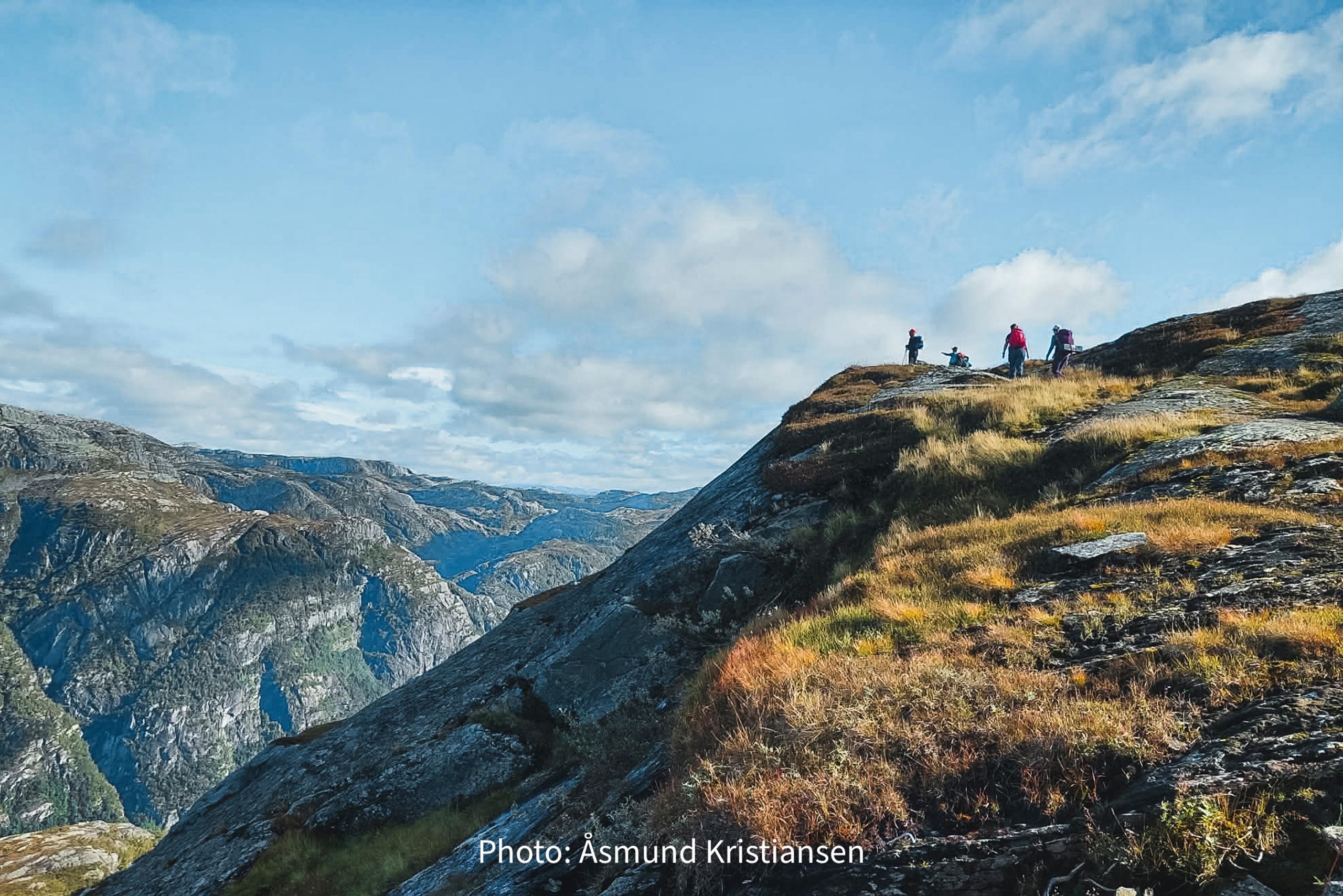 Hikers on a mountain ridge overlooking dramatic landscapes in Hardanger, Norway, ideal for hiking and outdoor adventures